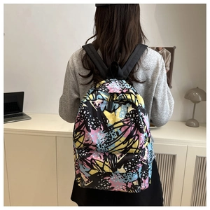 Graffiti printed backpack with colorful patchwork shown from a 45-degree back view