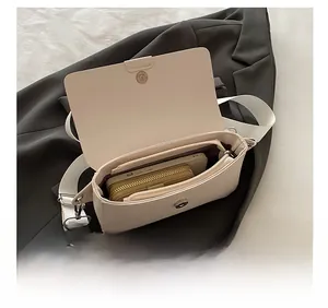 Interior view of cream leather shoulder bag showing spacious main compartment and zipper pocket