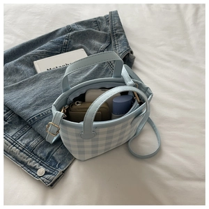 Top view of mini light blue checkered bag showing interior space for phone and makeup