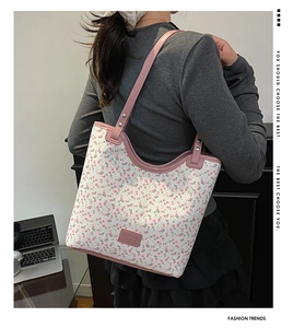 Détail d'un sac cabas floral avec bandoulières roses et étiquette logo à la mode