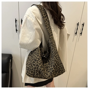 Close-up of leopard print canvas tote bag showing textured fabric and wide shoulder strap