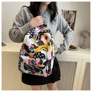 Detail view of the colorful graffiti backpack with front zipper pocket on a model