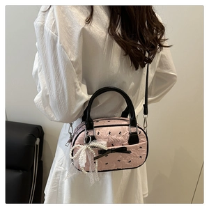 Pink quilted crossbody bag detail with lace pearl pendant and bow charm accessory