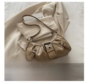 Detail shot of vintage brown leather texture and large metal buckle on the shoulder bag