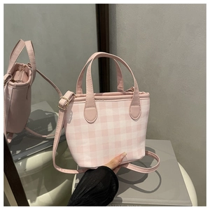 Detail of pink plaid mini tote bag with adjustable shoulder strap and leather top handles