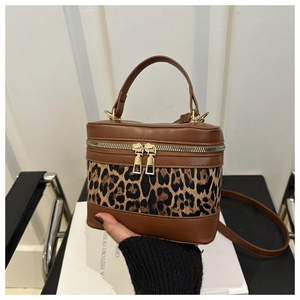 Detail of leopard print bucket bag with gold hardware and brown leather trim
