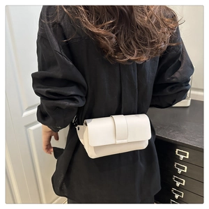 Minimalist beige leather waist bag shown on model with black shirt in a modern setting