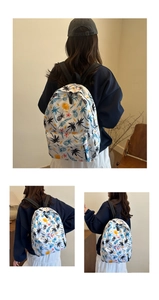 Detail view of white canvas backpack featuring tropical palm trees and colorful pineapple prints