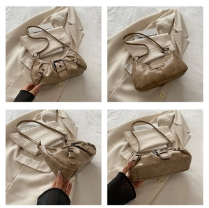 Detail view of vintage brown faux leather shoulder bag with metal buckle straps and texture
