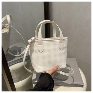 Detailed view of checkered tote bag with reinforced handles and secure zip closure