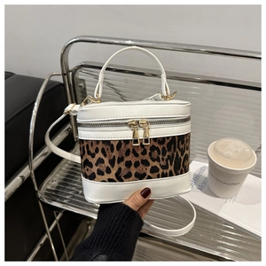 Detail of leopard print bucket bag with contrast stitching and golden zipper closure