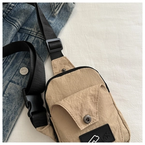 Detailed shot of khaki fanny pack with adjustable strap and front snap pocket