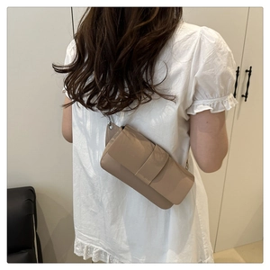 Minimalist beige rectangular crossbody bag shown on model for size and fit perspective