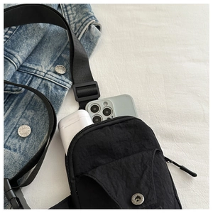 Detail showing internal capacity of nylon sling bag with smartphone and power bank