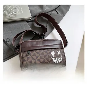Close-up of brown checkerboard crossbody bag with a white graffiti smile on a grey blazer