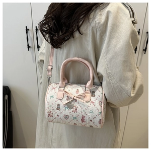Détail du mini sac Boston avec motifs d'ours roses et pendentif en cœur métallique