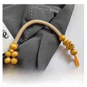 Dettaglio di borsa retrò in stile cinese con manici in perline di legno e jacquard