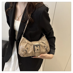Detail of vintage champagne gold shoulder bag with metallic buckles and pleated texture