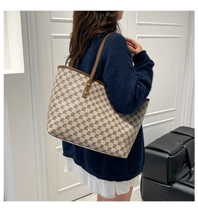 Detail of vintage canvas tote bag with letter jacquard pattern and brown leather straps