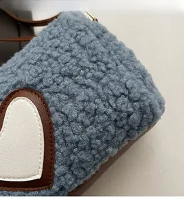 Gros plan détaillé sur la texture en peluche bleue et l'écusson en cuir en forme de coeur