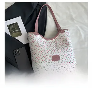Vue détaillée du sac cabas en toile fleurie avec bordure en cuir rose et étiquette