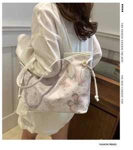 Detail der rosa Umhängetasche mit Schmetterlingsdruck und Kordelzug am Model