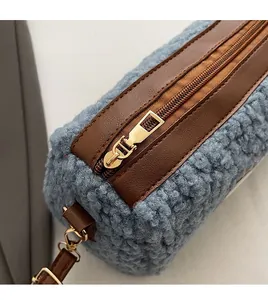 Gros plan détaillé en polaire peluche bleue avec bordure en cuir brun et zip doré