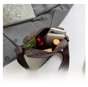 Internal capacity of brown checkered crossbody bag showing storage for phone and makeup