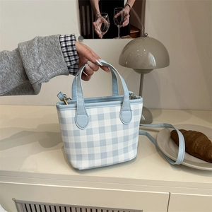 Chic blue and white plaid crossbody bag with leather handles in a retro aesthetic
