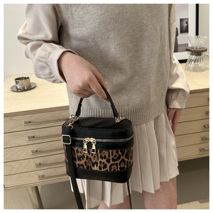 Detail of the leopard print contrast stitching and golden hardware on this bucket bag