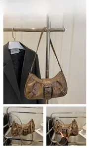 Detail of vintage brown shoulder bag showing retro faux leather and large metal buckle