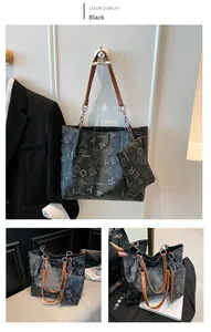 Détail du sac cabas noir imprimé avec pochette assortie et chaîne en métal argenté