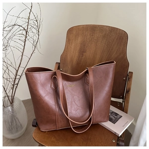 Macro shot of brown PU leather tote bag texture with fashion text on a wooden chair