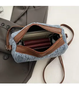 Vue ouverte du sac bandoulière en fausse fourrure bleue montrant l'espace intérieur