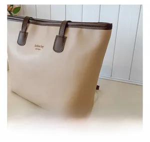 Detalle del bolso tote beige con cuero PU granulado y relieve dorado de tendencia