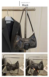 Detail of vintage black faux leather shoulder bag with large metal buckle and retro texture