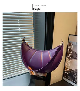 Detailed view of purple crescent shoulder bag with pleated leather and gold hardware