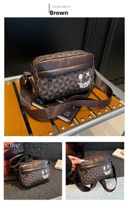 Detail of a brown crossbody bag with geometric patterns and a graffiti smiley face