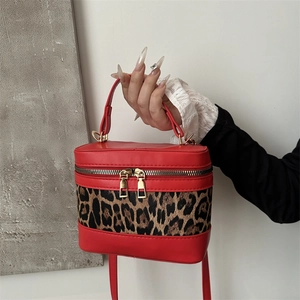 Leopard print bucket bag with red leather trim and golden zipper for shoulder or crossbody use