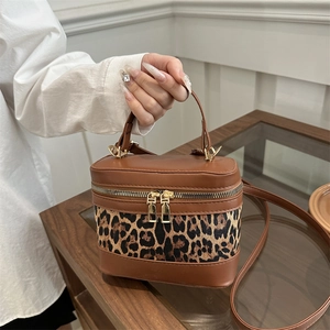 Leopard print bucket bag with brown leather trim and dual gold zippers for women