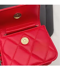 Macro shot of the durable magnetic hardware clasp on a red quilted leather handbag