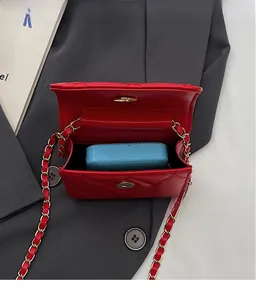 Top view of red quilted mini chain bag interior showing storage space on grey blazer