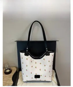 Détail du sac cabas blanc avec broderie florale rose et anses en cuir noir