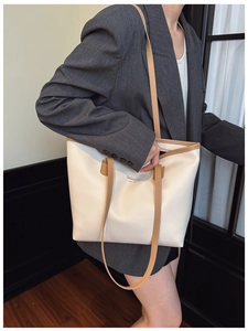 Detalle del bolso tote bicolor con letras de NEW YORK y correas de cuero PU marrón