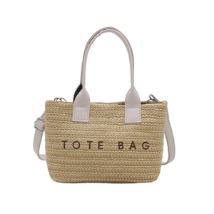 Straw tote bag with white leather handles and embroidered TOTE BAG text for summer vacation
