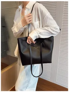 Detalle del bolso tote de cuero granulado negro con costuras en contraste para mujer