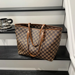 Large vintage brown checkered tote bag with leather handles on modern steps