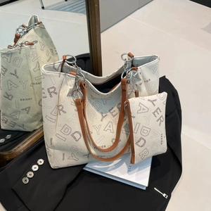 Grand sac cabas beige avec motifs de lettres, lanières en cuir marron et pochette assortie