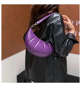 Detail of purple crescent shoulder bag with vertical quilted leather and gold hardware