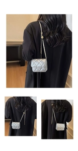 Detail of silver quilted mini crossbody bag with gold ball chain and metallic finish